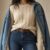 Fashion editorial header: cream cable knit, denim jacket on shoulders, indigo jeans, quiet loft light