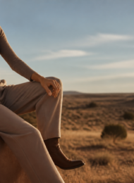 Woman in ribbed taupe loungewear with concho belt and boots at golden hour