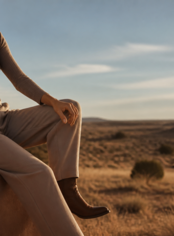 Woman in ribbed taupe loungewear with concho belt and boots at golden hour