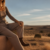 Woman in ribbed taupe loungewear with concho belt and boots at golden hour