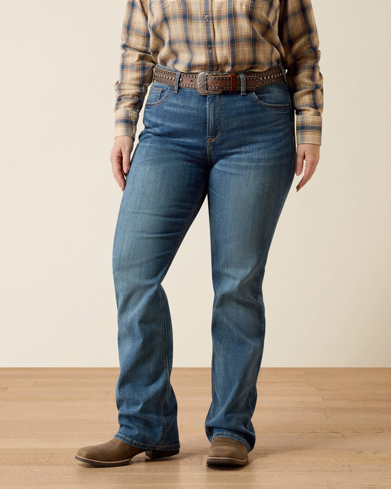 Bootcut jeans with a plaid shirt and cowboy boots for a weekend look