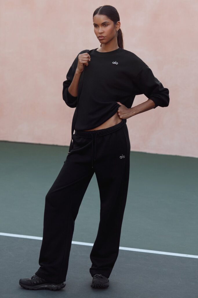 Alo Accolade Straight Leg Sweatpant in black, a long straight-leg French terry sweatpant worn with a black top