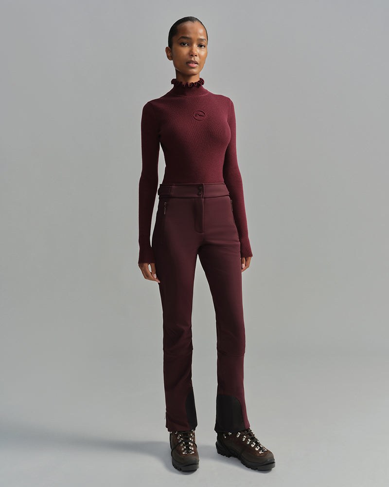 Cordova Kitz fitted ski sweater with a tall ruffled collar in bordeaux, an apres ski outfit layer