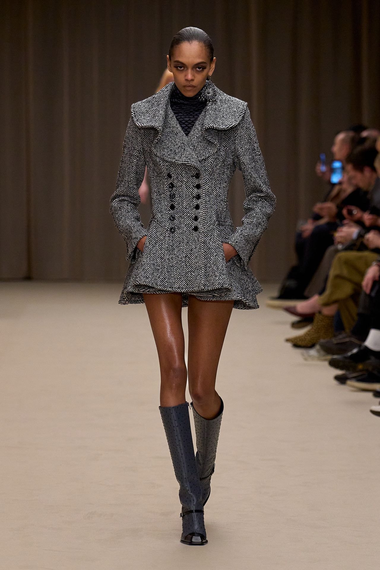 McQueen Fall 2026 look 1: gray herringbone double-breasted coat with knee-high boots