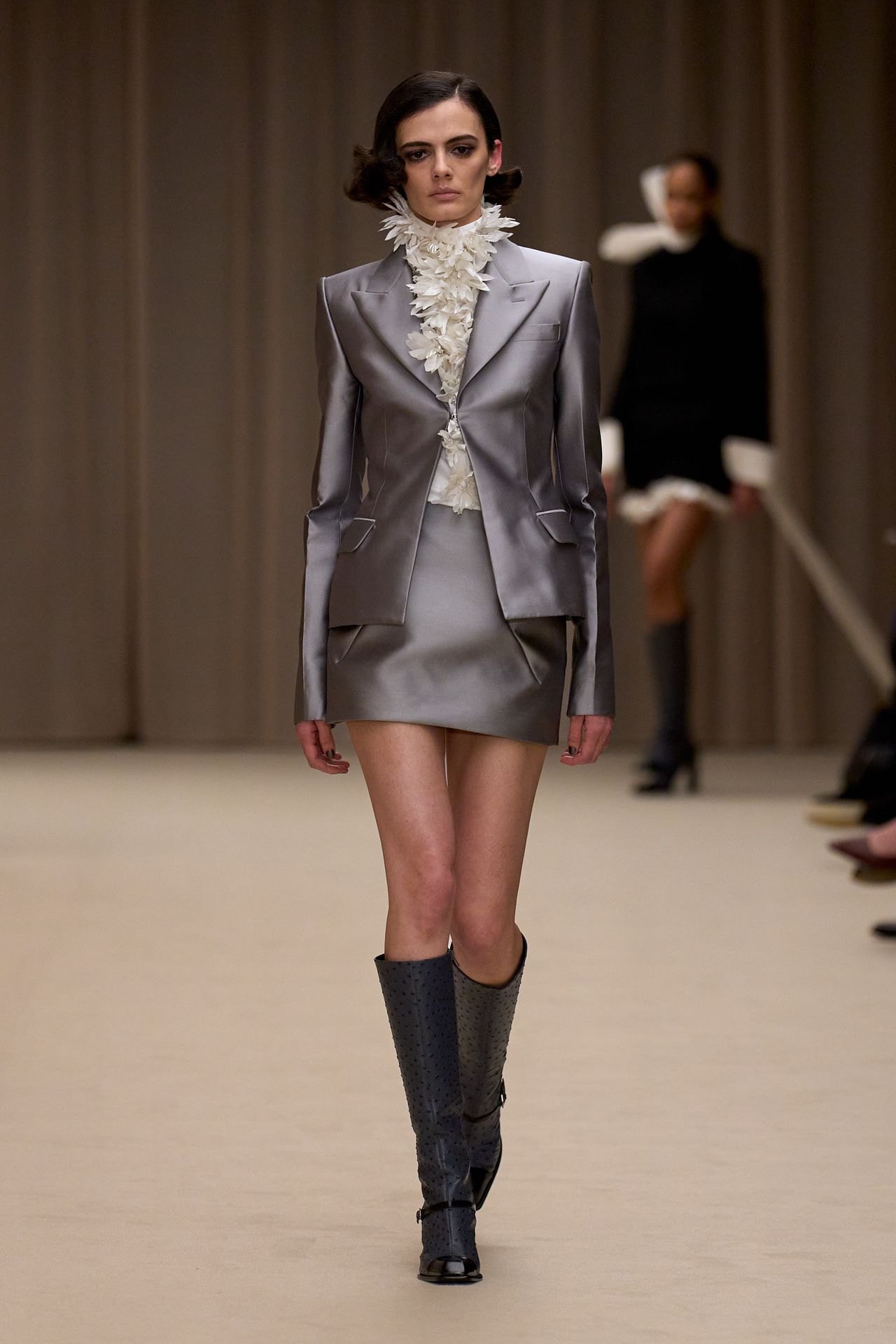 McQueen Fall 2026 look 5: silver-gray tailored jacket and mini skirt with knee-high boots